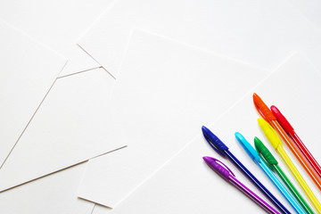 Bright colored pens on sheets of white paper