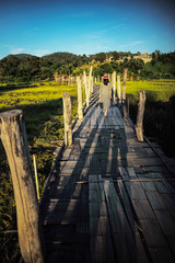 Fototapeta premium Women walk on a small wooden bridge.