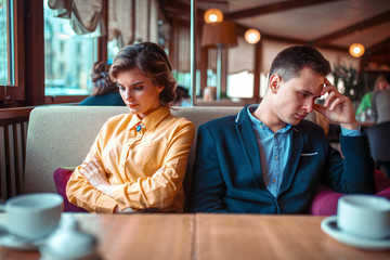 Couple in a bad mood sitting in restaurant