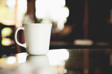 vintage tone of cup of coffee on table in Coffee shop blur background with bokeh image.