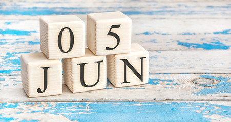 June 5th. Wooden cubes with date of 5 June on old blue wooden background.