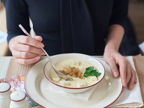 Woman Eating Cheese Cream Soup Served With Baked Apples. Woman Hands And Plate