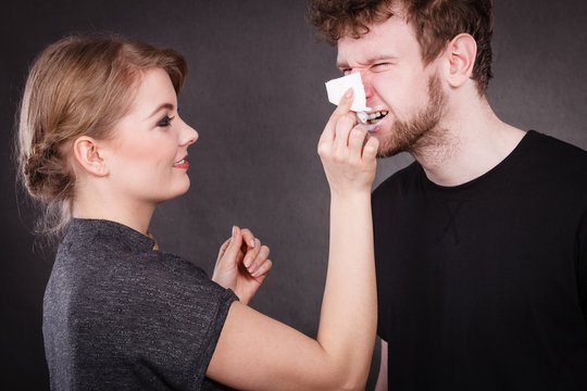 Girl taking off the cream from boy face.