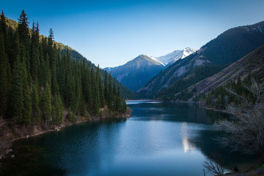 Majestic blue mountain lake with green trees