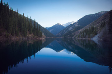 Naklejka na ściany i meble Majestic blue mountain lake with green trees