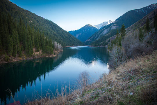 Majestic blue mountain lake with green trees