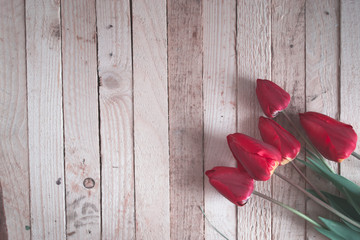 Fototapeta na wymiar Red tulips on wooden boards.