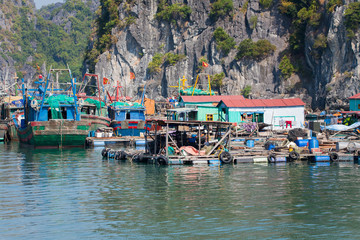 Fototapeta na wymiar Floating fishing village with rock island in background, Ha Long bay, Vietnam.