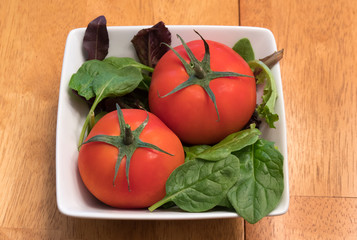 Healthy and colorful tomatoes and spinach leaves