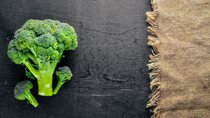 Fresh broccoli on dark wooden table background. top view