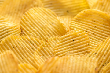 close up rippled natural potato chips with salt and greenery