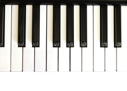 Piano keyboard with white and black keys on white background top view vertical  photo close up
