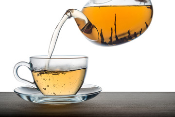close up of pouring tea from teapot on wooden over white background, mockup