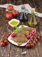 Chicken fillet in marinade with olive oil and olives on a wooden board. 