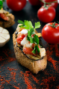 Tasty savory tomato Italian bruschetta, on slices of toasted baguette garnished with parsley and eggplant