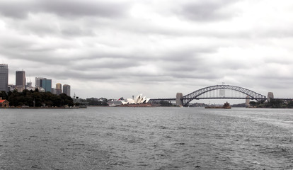 Skyline von Sydney mit Opera House und Harbour Bridge an einem bewölkten Tag.