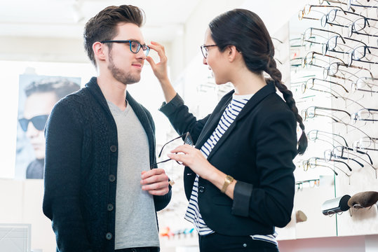 Frau und Mann kaufen Brille im Optiker Laden