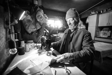 Man sewing fabric bw