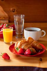 Tasty breakfast with croissants and strawberries