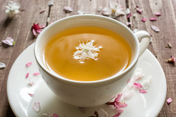 cup of green flower tea and blossoming cherry flowers