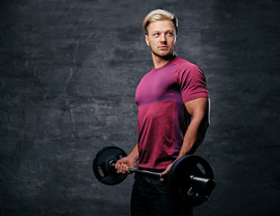 Fototapeta na wymiar Athletic blond male doing a biceps workout with a barbell.