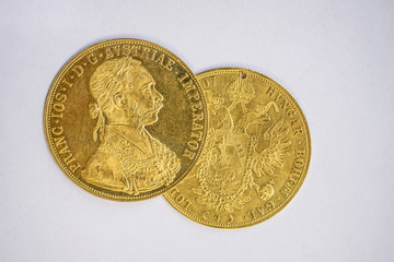Close-up view of two on one another Austria-Hungary thalers, avers and revers of golden coin-ducats...
