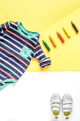 children flat lay with clothes yellow background top view space for text