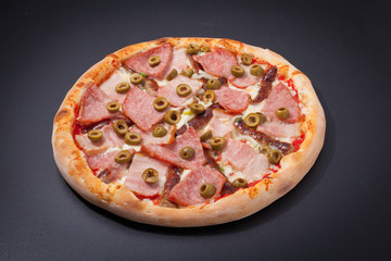 Pizza with bacon on a matte black board