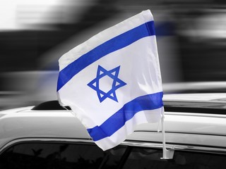 Flag of Israel on the Car on Independence Day. Background in the black and white colors and motion...