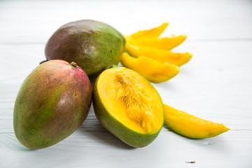 Mango fruits closeup on white wooden background,