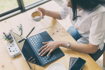 Successful business woman working on the laptop computer and holding coffee cup,Working with laptop on the desk,selective focus and film look color tone