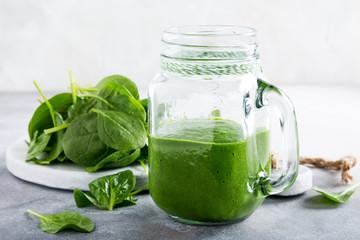 Healthy green smoothie with spinach in glass jar and ingredients. Detox, diet, healthy, vegetarian food concept with copy space.