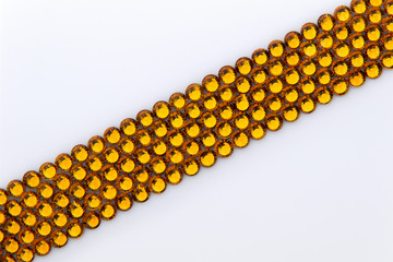 Precious sparkling rhinestones Topaz colors on a white background.