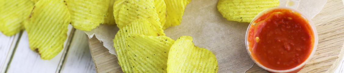 Horizontal bakground of potato chips on a table