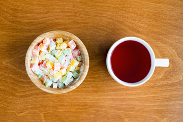 Plate with multicolored Turkish delight and a cup of cranberry fruit drink