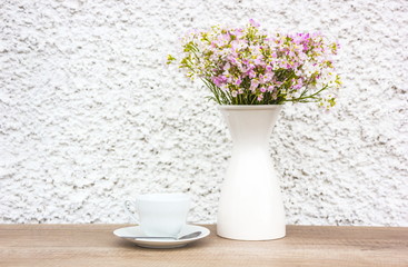 White cup and vase flowers