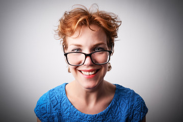 Attractive middle aged woman smiling and posing for the camera in glasses.