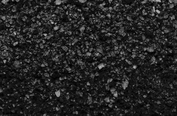 Sea salt background or texture in black color. Little minerals