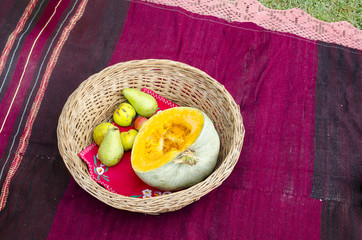 Ethno basket, fruit and old traditional red rug