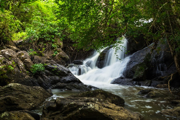 PHA KLUAI MAI waterfall with green trees and stones.