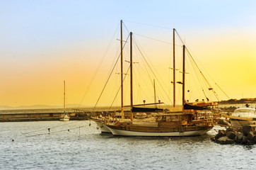 Old wooden ship at the dock in the port of the old town of Nessebar, on the Black Sea coast at sunset