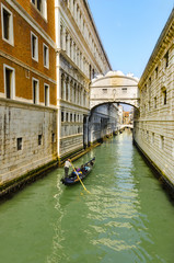 Gondolier on gondola ride under Bridge of Sights in Venice, Italy