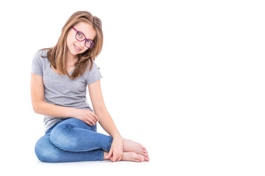 Young Pre-Teen girl in blue jeans and grey t-shirt isolated on white.
