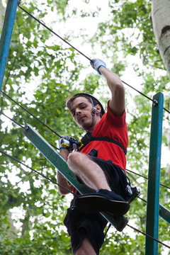 man in adventure park on  tree top