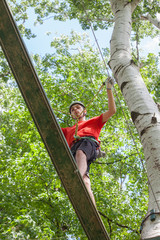 man in adventure park on  tree top