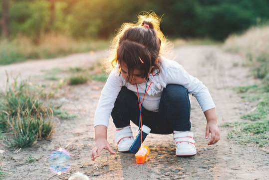 Little girl playing with soap balloons.