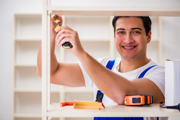 Worker man repairing assembling bookshelf