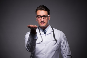 Young doctor against dark background