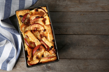 Freshly baked bread pudding in casserole dish on wooden table