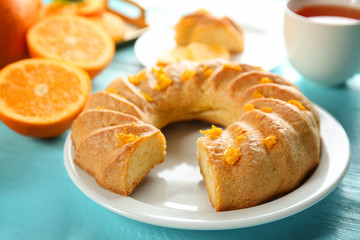 Plate with sliced citrus cake on blue wooden table